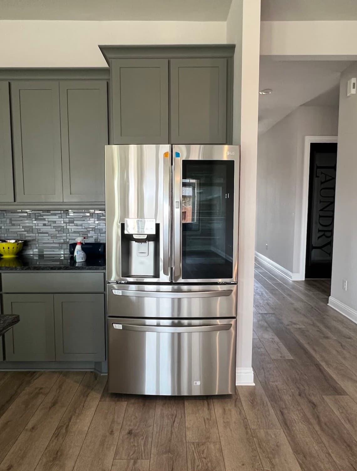 Stainless four-door InstaView refrigerator installed in a cabinet surround